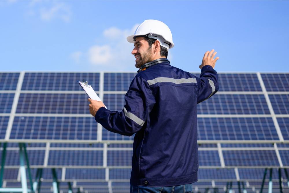 engineer-worker-portrait-with-solar-panel-at-solar-farm.jpg